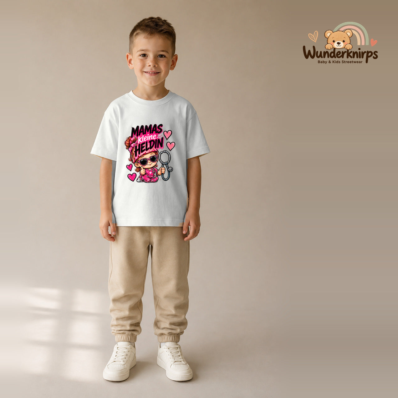 T-Shirt für Jungen in Weiß mit Motiv „Mamas kleine Heldin“, getragen von einem Kind – Wunderknirps.