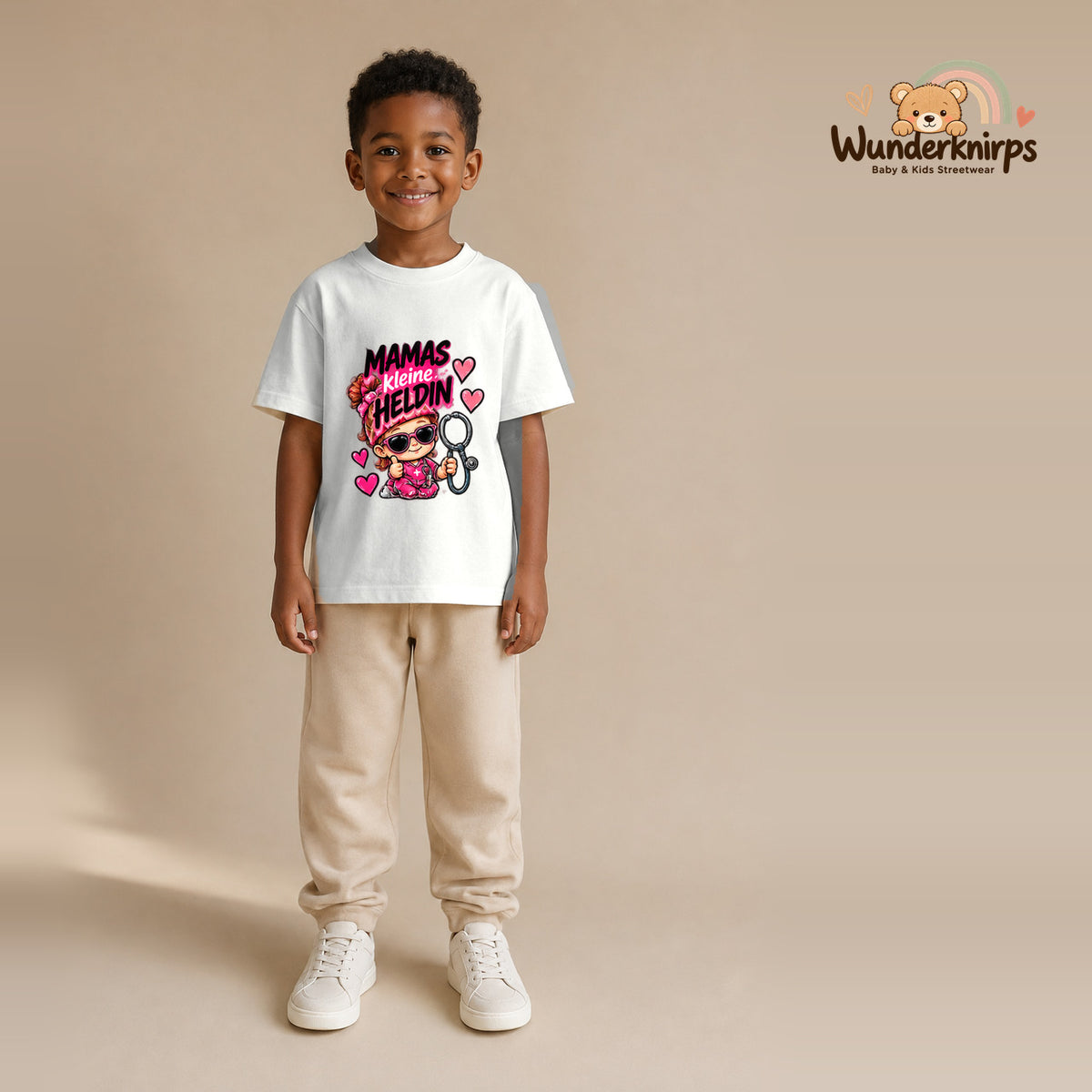 T-Shirt für Jungen in Weiß mit Motiv „Mamas kleine Heldin“, getragen von einem Kind – Wunderknirps.