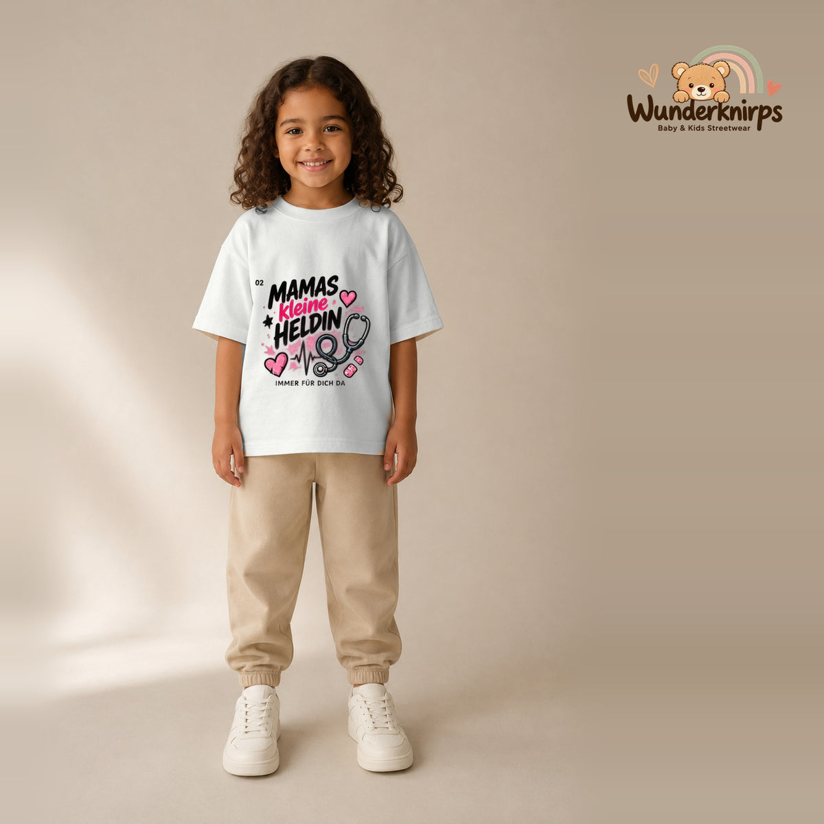 T-Shirt für Mädchen in Weiß mit Motiv „Mamas kleine Heldin“, getragen von einem Kind – Wunderknirps.