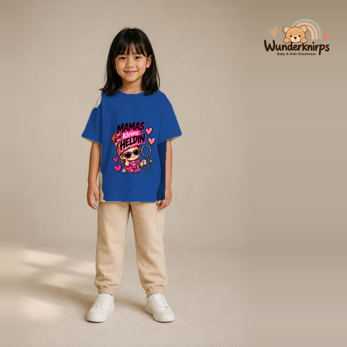 T-Shirt für Mädchen in Blau mit Motiv „Mamas kleine Heldin“, getragen von einem Kind – Wunderknirps.