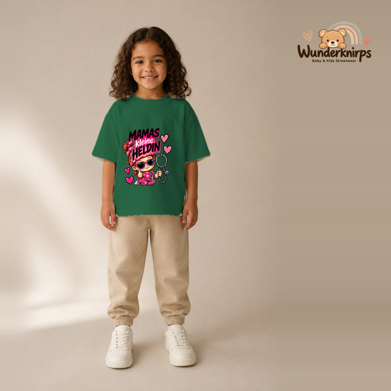 T-Shirt für Mädchen in Grün mit Motiv „Mamas kleine Heldin“, getragen von einem Kind – Wunderknirps.