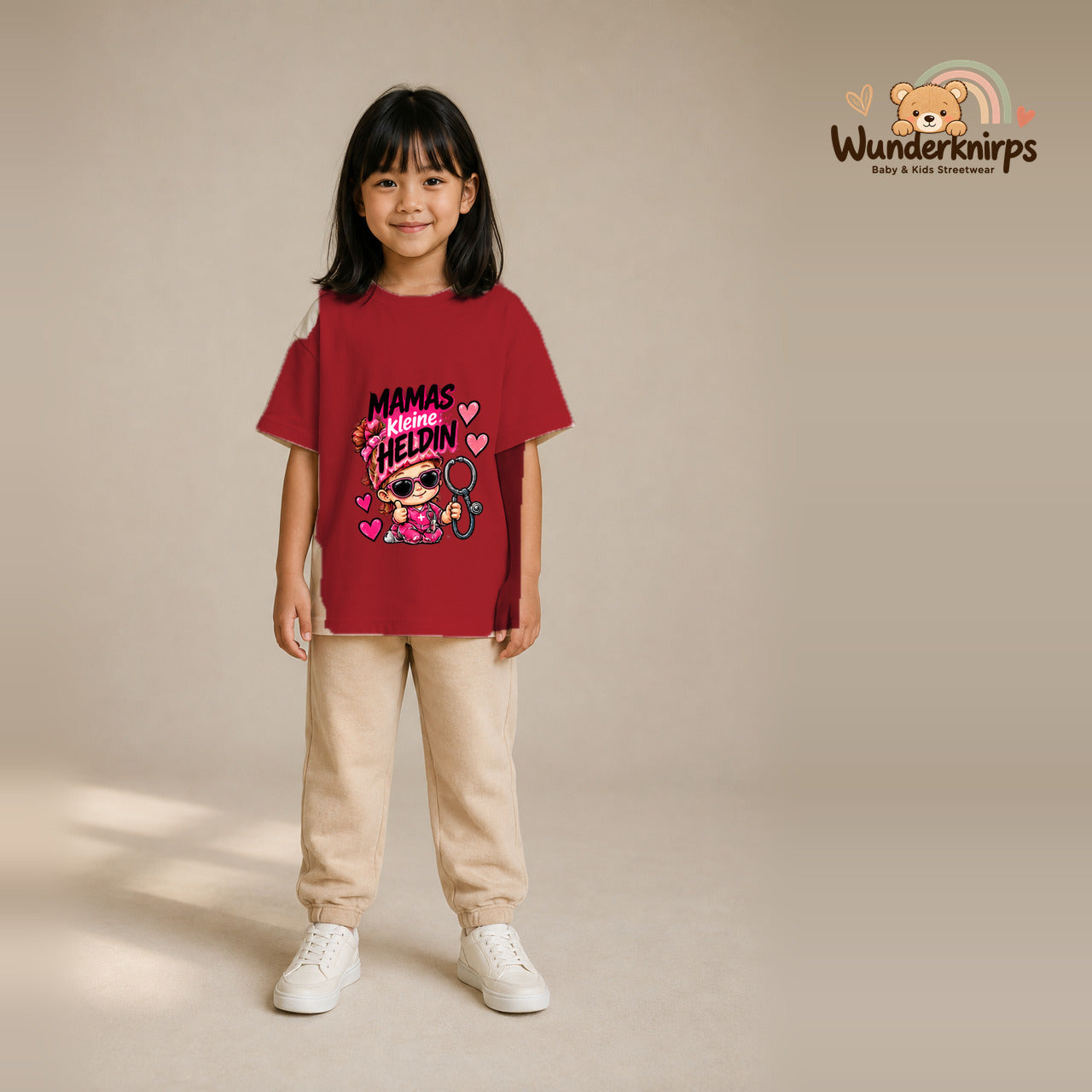 T-Shirt für Mädchen in Rot mit Motiv „Mamas kleine Heldin“, getragen von einem Kind – Wunderknirps.