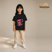 T-Shirt für Mädchen in Schwarz mit Motiv „Mamas kleine Heldin“, getragen von einem Kind – Wunderknirps.