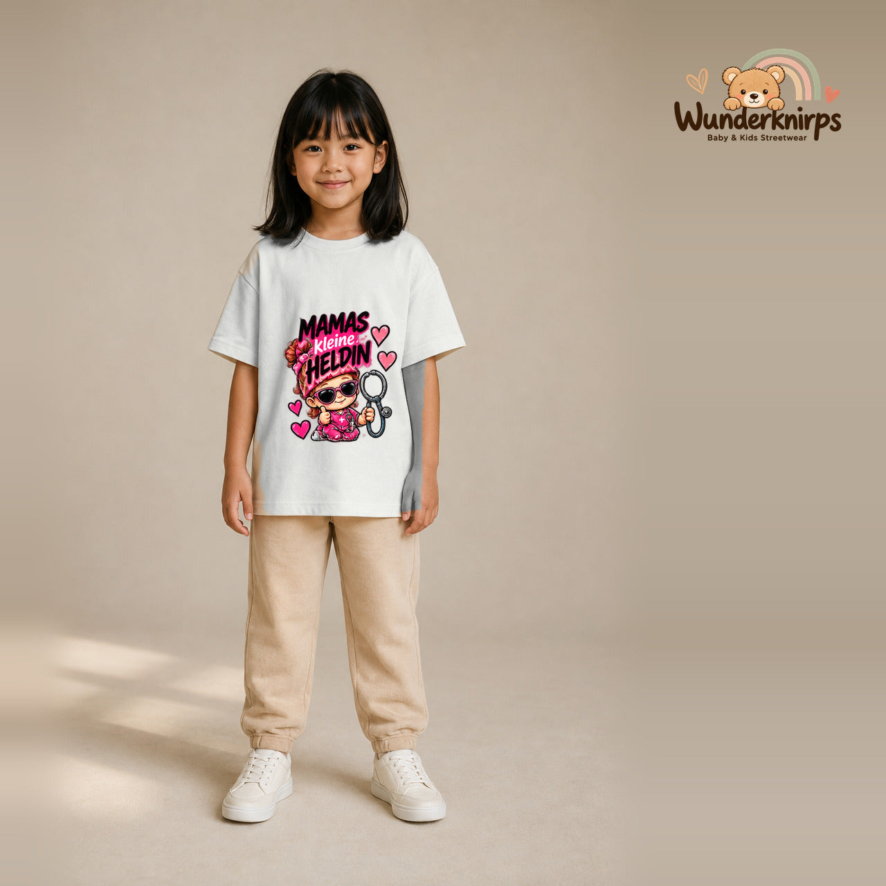 T-Shirt für Mädchen in Weiß mit Motiv „Mamas kleine Heldin“, getragen von einem Kind – Wunderknirps.