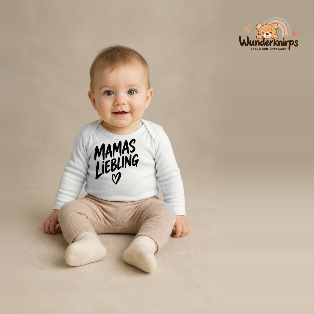 Babybody für Jungen in Weiß mit Motiv „Mamas Liebling“, getragen von einem Kind – Wunderknirps.