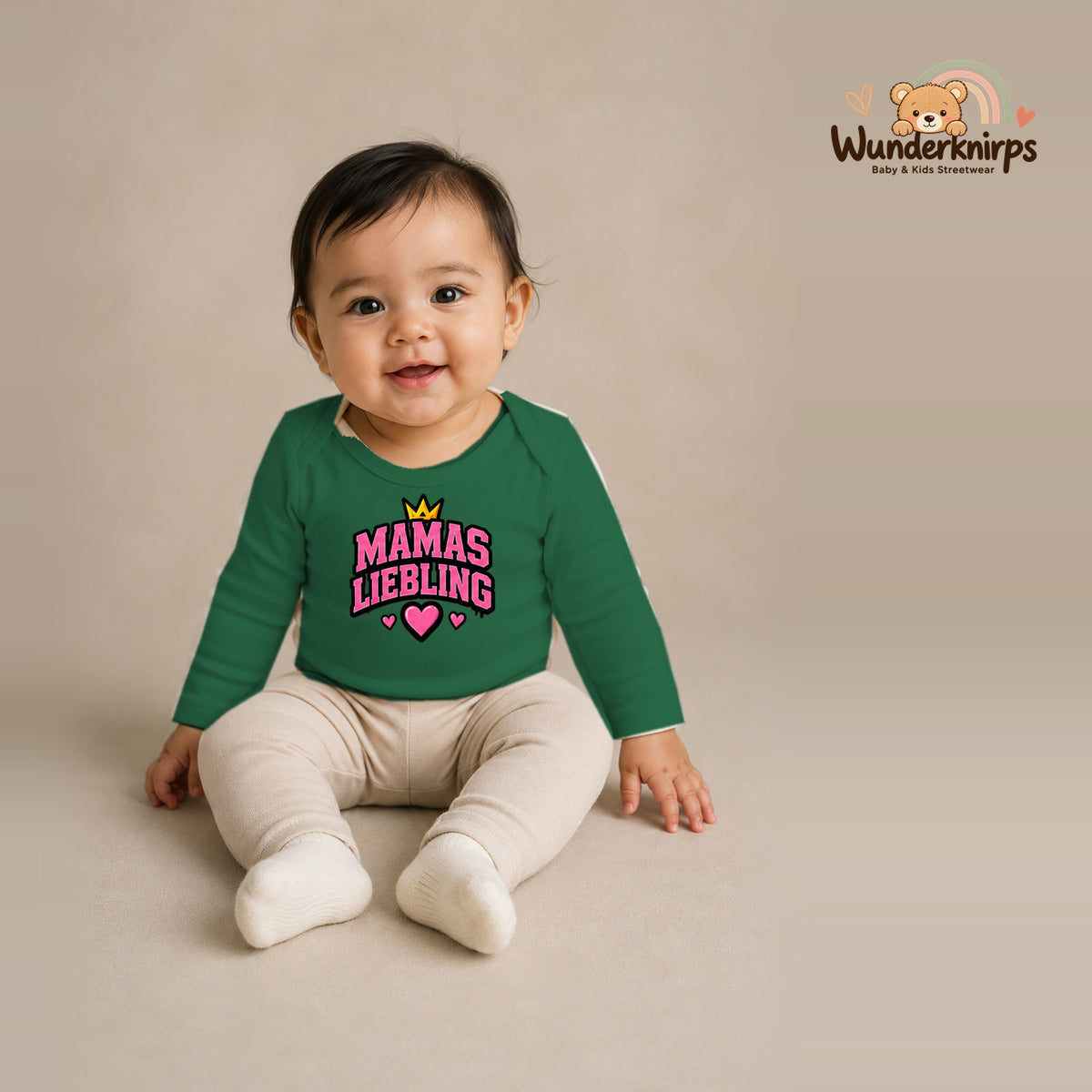 Babybody für Mädchen in Grün mit Motiv „Mamas Liebling“, getragen von einem Kind – Wunderknirps.