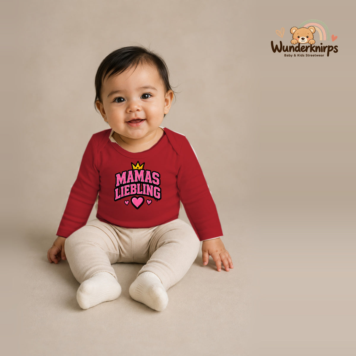 Babybody für Mädchen in Rot mit Motiv „Mamas Liebling“, getragen von einem Kind – Wunderknirps.