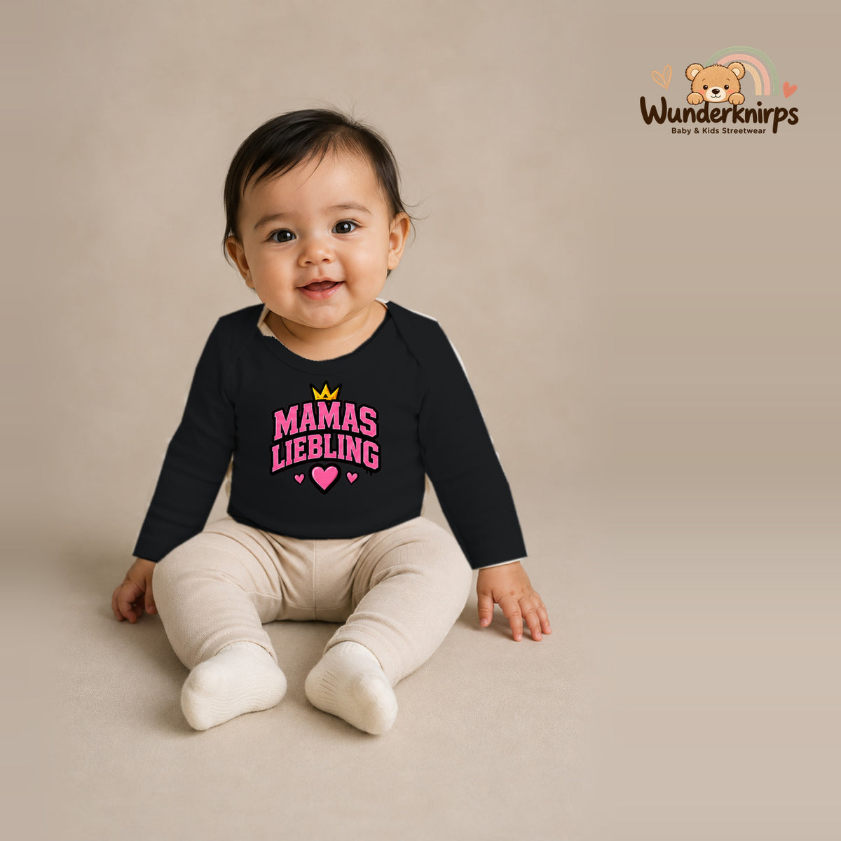 Babybody für Mädchen in Schwarz mit Motiv „Mamas Liebling“, getragen von einem Kind – Wunderknirps.