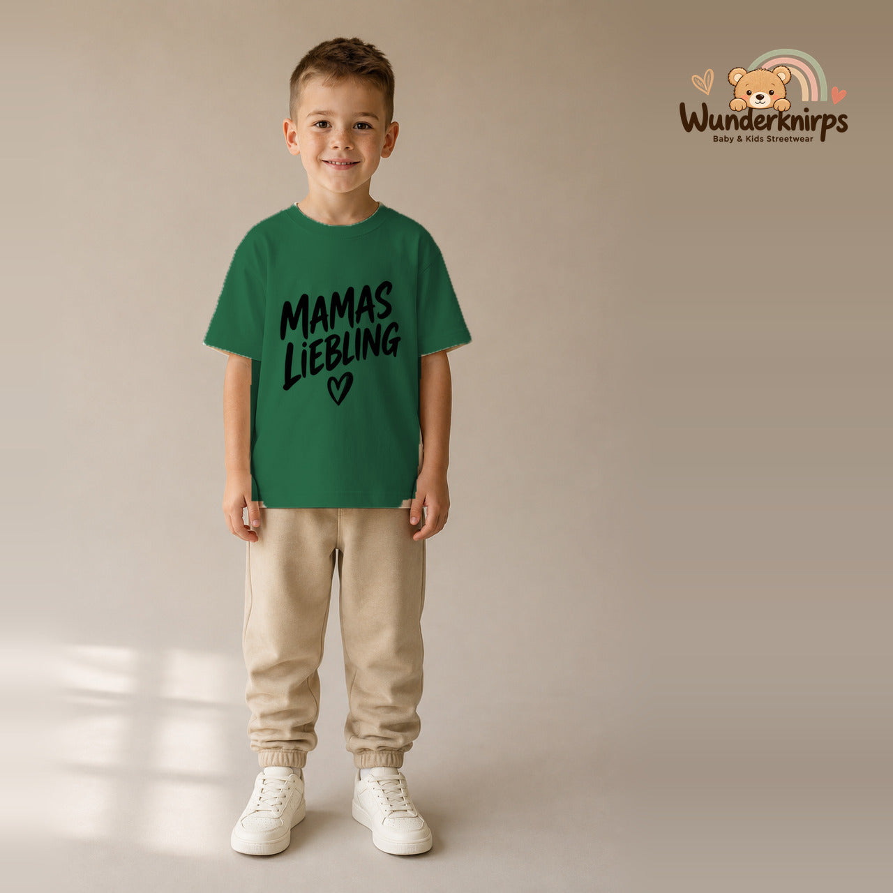 T-Shirt für Jungen in Grün mit Motiv „Mamas Liebling“, getragen von einem Kind – Wunderknirps.