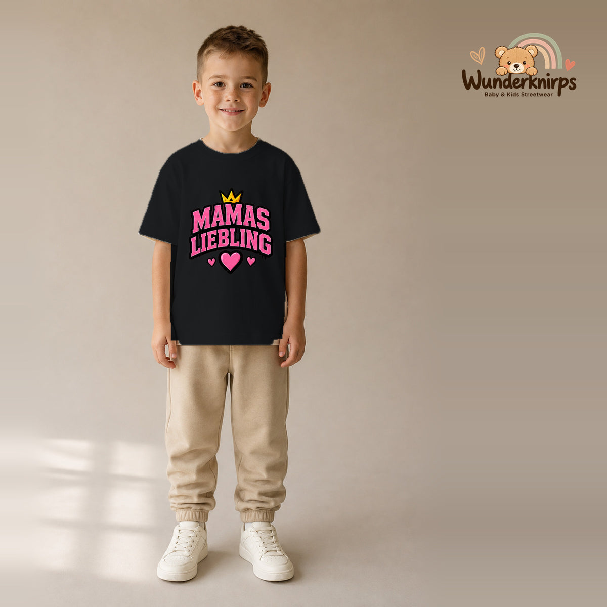 T-Shirt für Jungen in Schwarz mit Motiv „Mamas Liebling“, getragen von einem Kind – Wunderknirps.