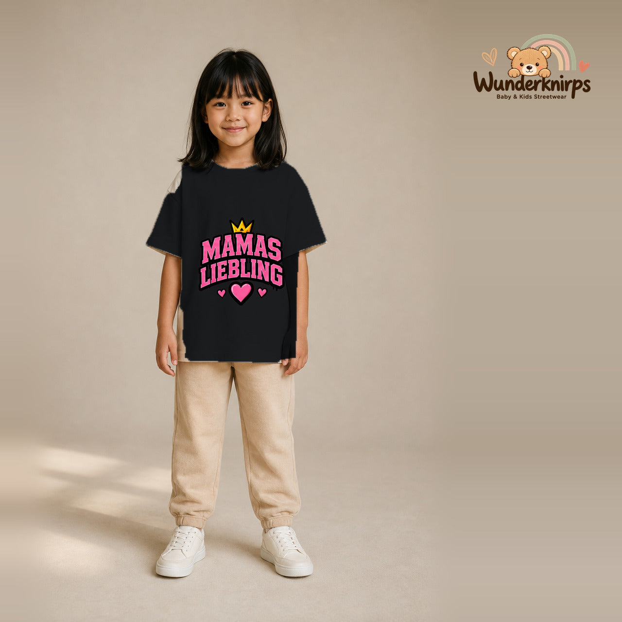 T-Shirt für Mädchen in Schwarz mit Motiv „Mamas Liebling“, getragen von einem Kind – Wunderknirps.