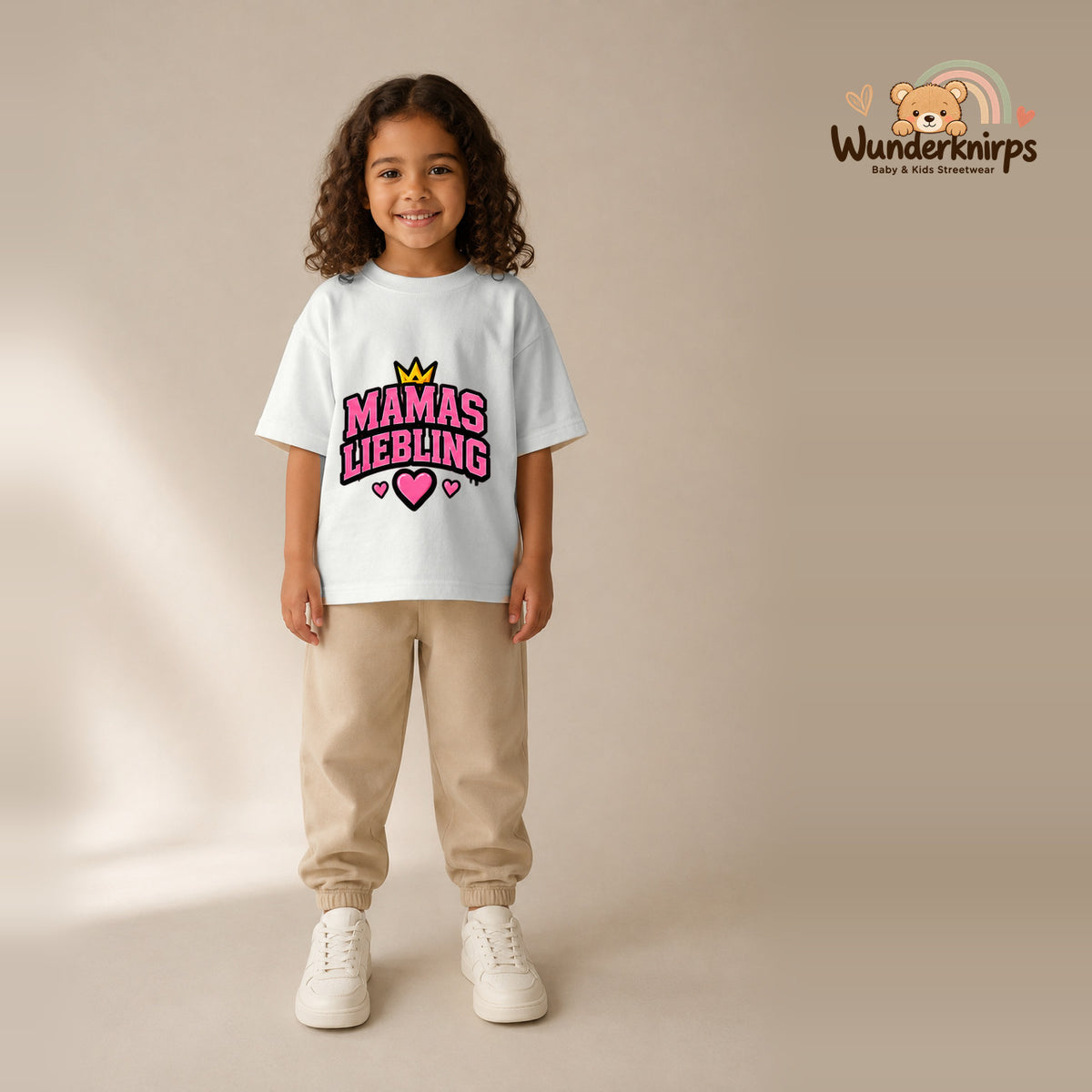 T-Shirt für Mädchen in Weiß mit Motiv „Mamas Liebling“, getragen von einem Kind – Wunderknirps.