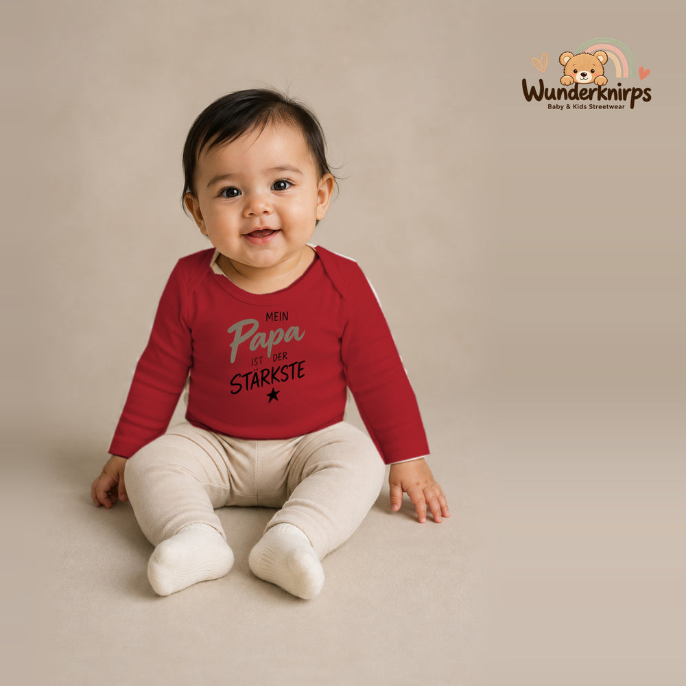 Babybody für Mädchen in Rot mit Motiv „Mein Papa“, getragen von einem Kind – Wunderknirps.