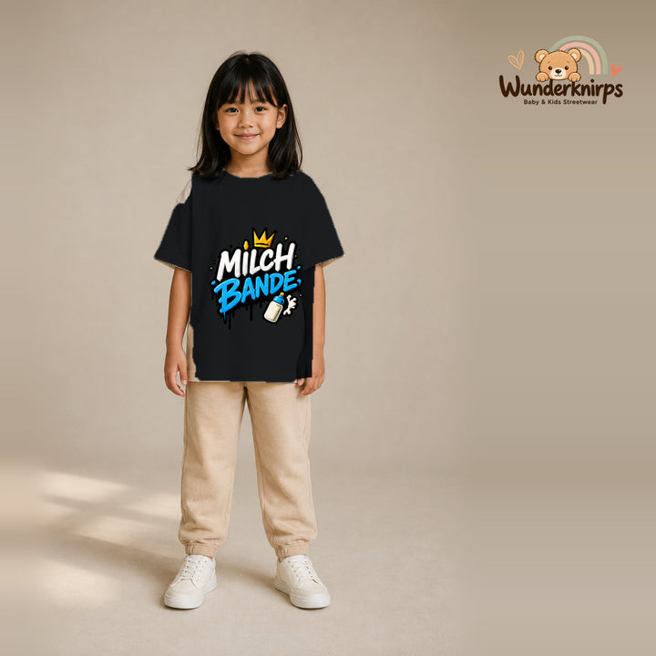 T-Shirt für Mädchen in Schwarz mit Motiv „Milchbande“, getragen von einem Kind – Wunderknirps.