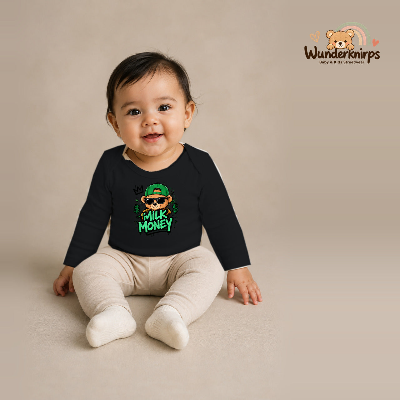 Babybody für Mädchen in Schwarz mit Motiv „Milk Money“, getragen von einem Kind – Wunderknirps.
