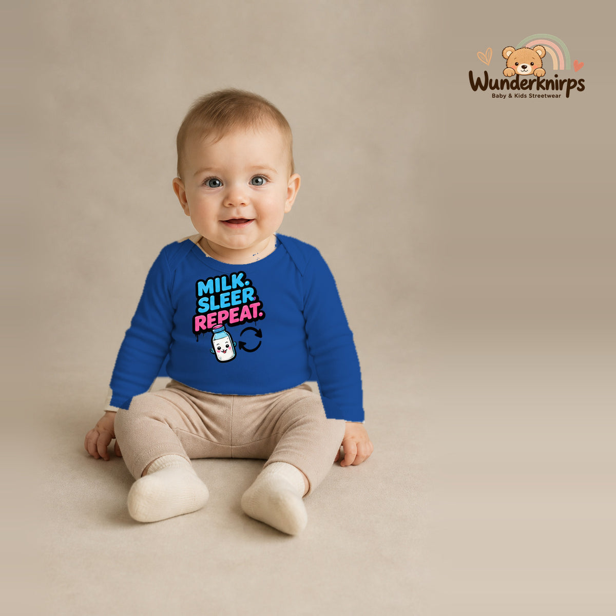 Babybody für Jungen in Blau mit Motiv „Milk Sleep Repeat“, getragen von einem Kind – Wunderknirps.