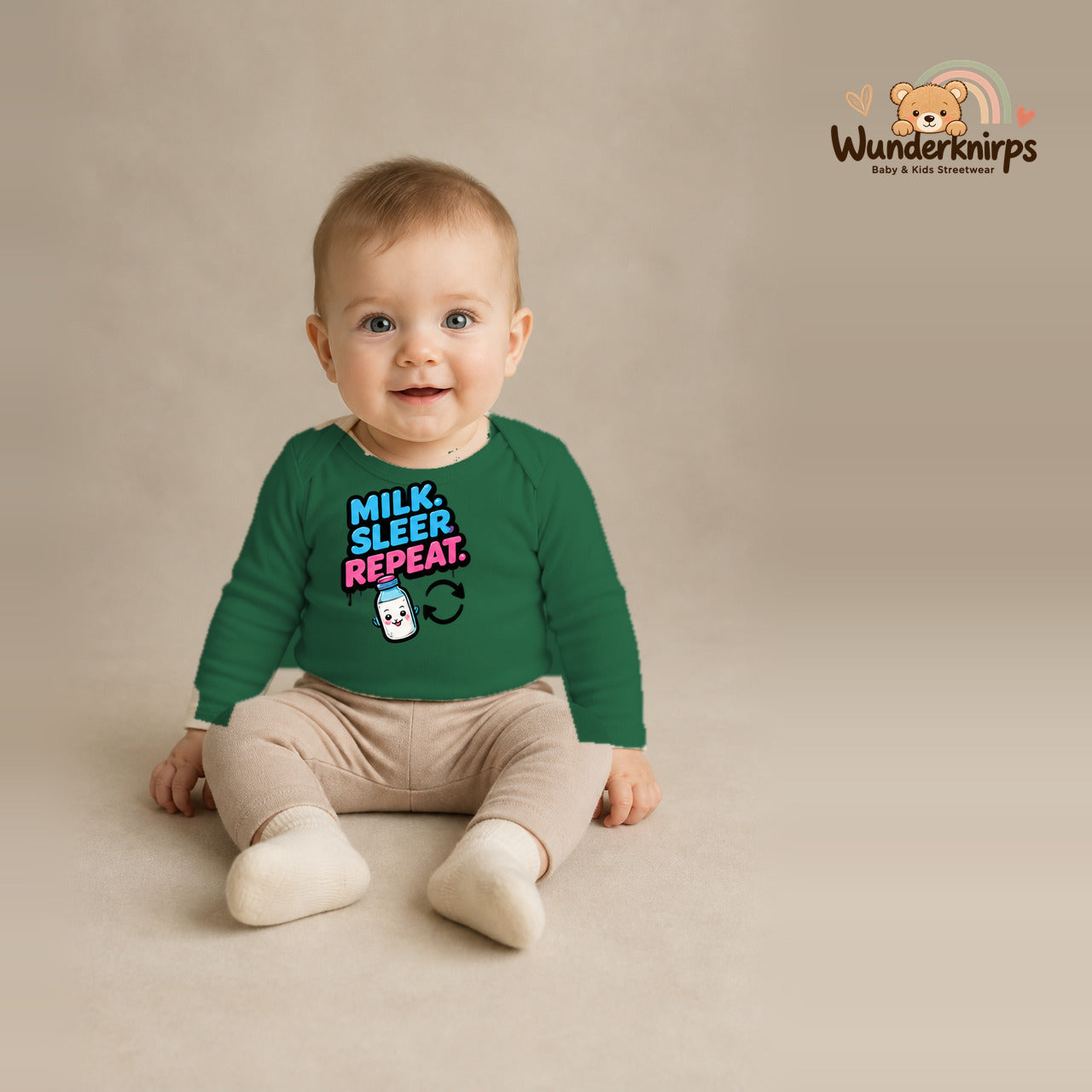 Babybody für Jungen in Grün mit Motiv „Milk Sleep Repeat“, getragen von einem Kind – Wunderknirps.