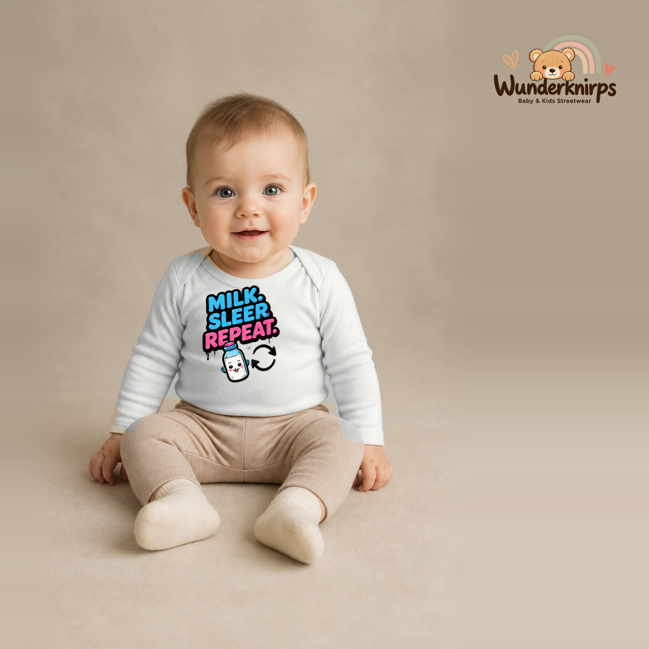 Babybody für Jungen in Weiß mit Motiv „Milk Sleep Repeat“, getragen von einem Kind – Wunderknirps.