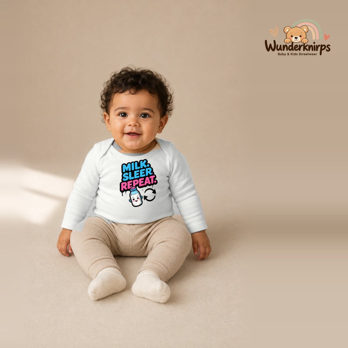 Babybody für Jungen in Weiß mit Motiv „Milk Sleep Repeat“, getragen von einem Kind – Wunderknirps.