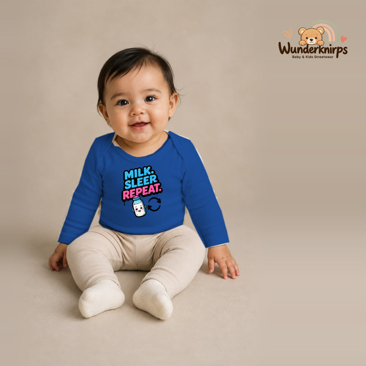 Babybody für Mädchen in Blau mit Motiv „Milk Sleep Repeat“, getragen von einem Kind – Wunderknirps.