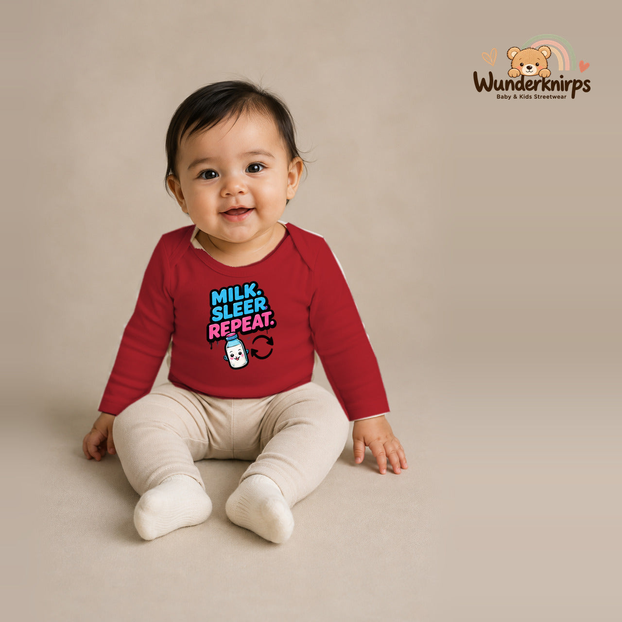 Babybody für Mädchen in Rot mit Motiv „Milk Sleep Repeat“, getragen von einem Kind – Wunderknirps.