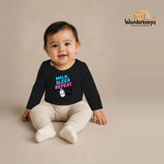 Babybody für Mädchen in Schwarz mit Motiv „Milk Sleep Repeat“, getragen von einem Kind – Wunderknirps.
