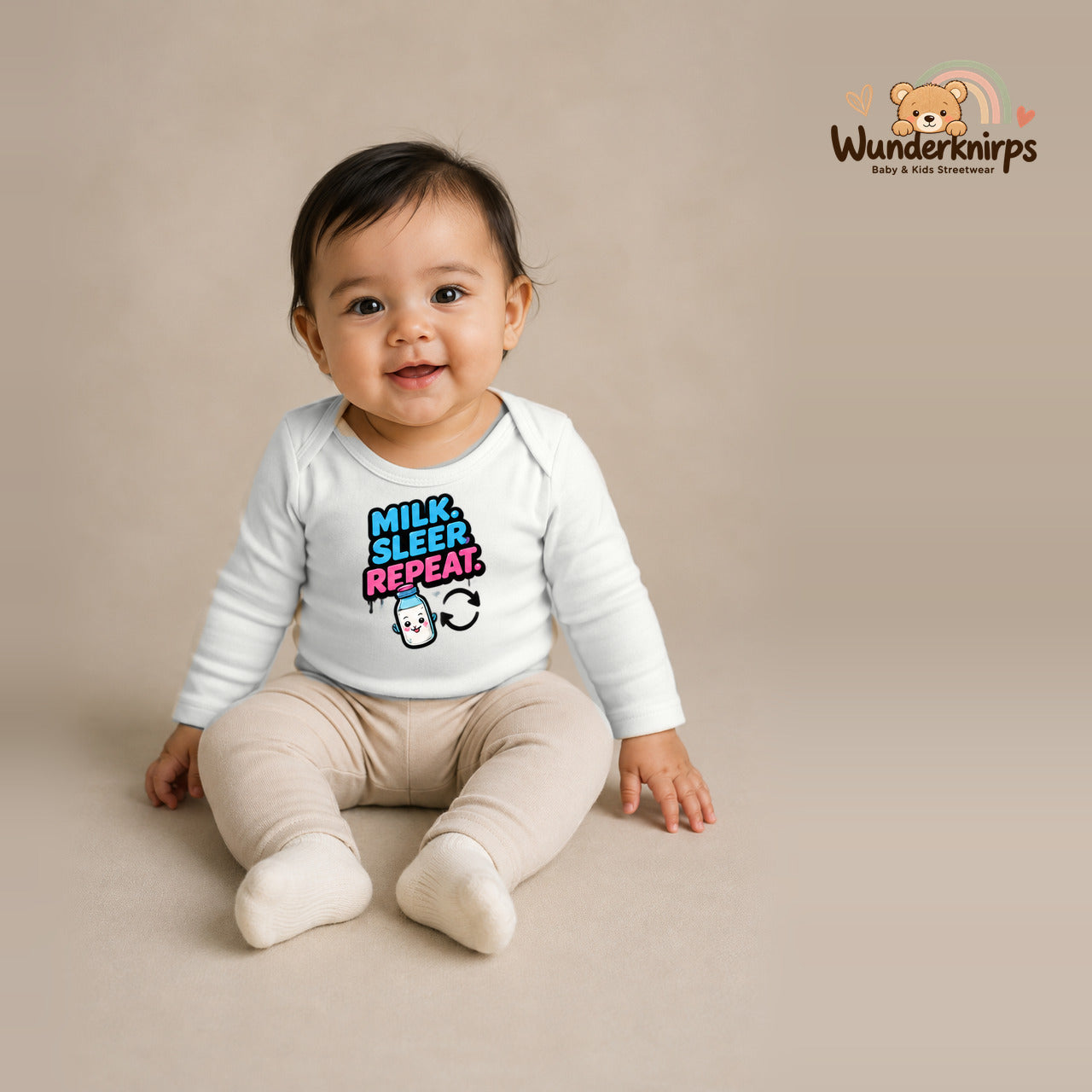 Babybody für Mädchen in Weiß mit Motiv „Milk Sleep Repeat“, getragen von einem Kind – Wunderknirps.