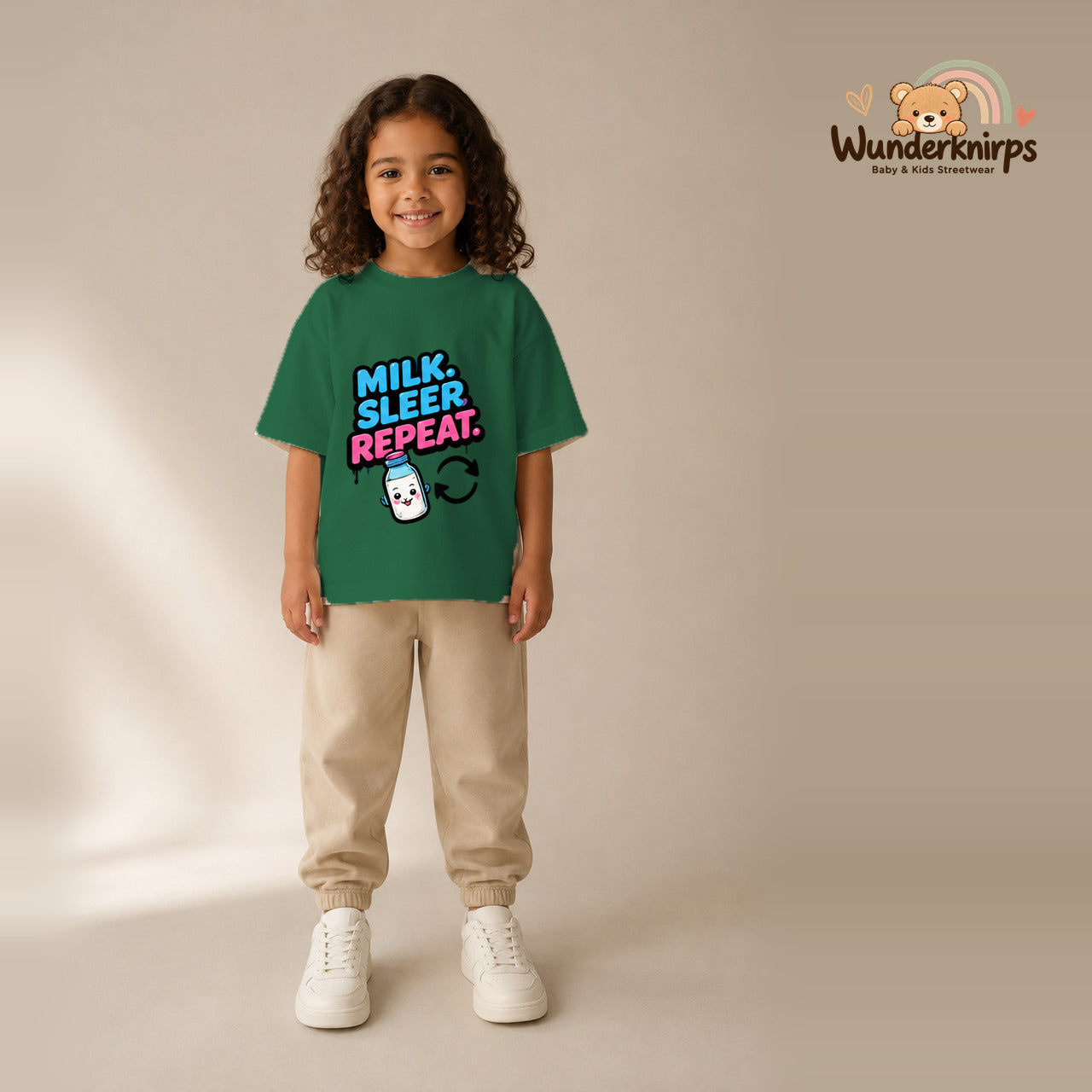 T-Shirt für Mädchen in Grün mit Motiv „Milk Sleep Repeat“, getragen von einem Kind – Wunderknirps.
