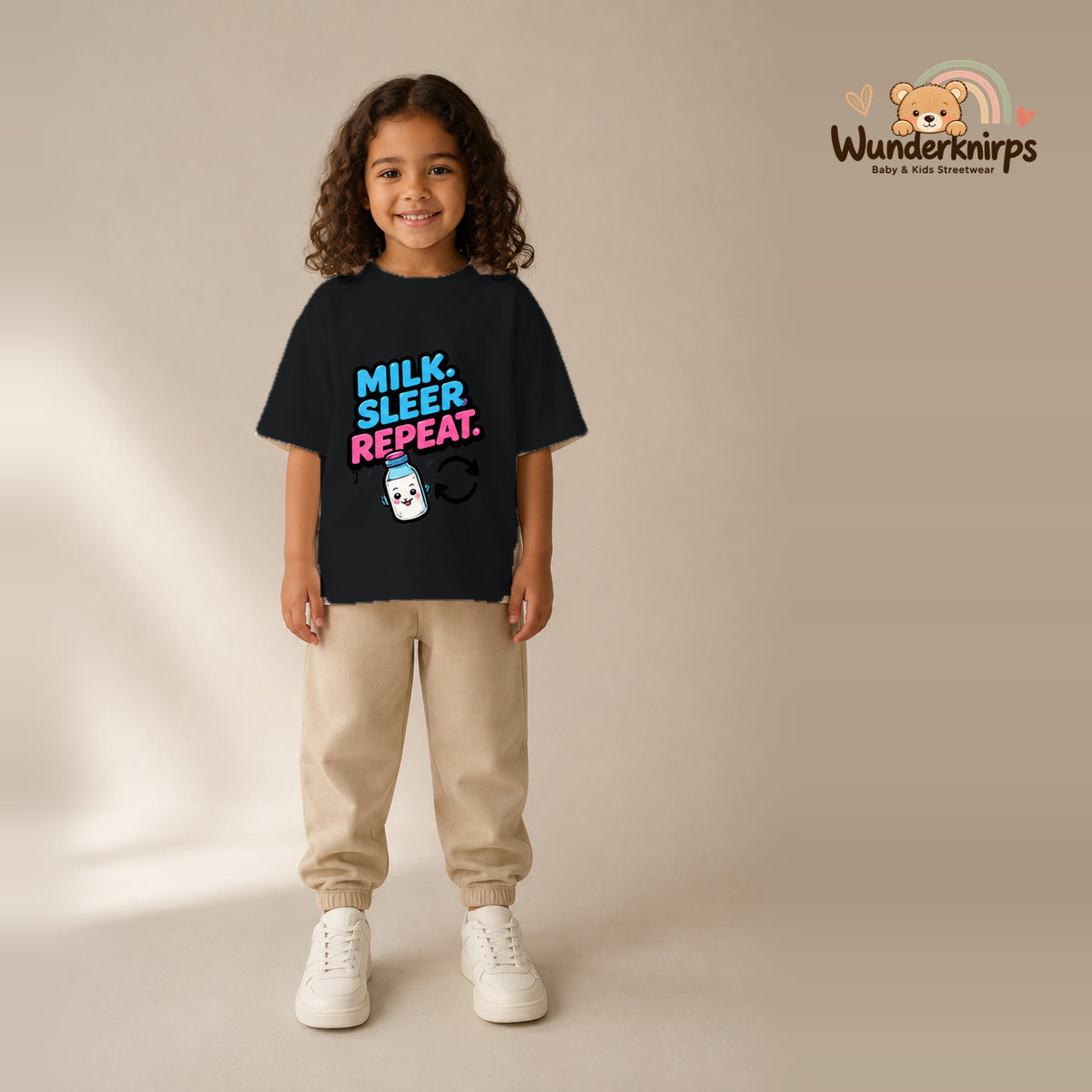 T-Shirt für Mädchen in Schwarz mit Motiv „Milk Sleep Repeat“, getragen von einem Kind – Wunderknirps.