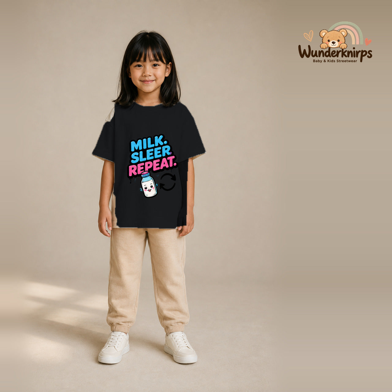 T-Shirt für Mädchen in Schwarz mit Motiv „Milk Sleep Repeat“, getragen von einem Kind – Wunderknirps.