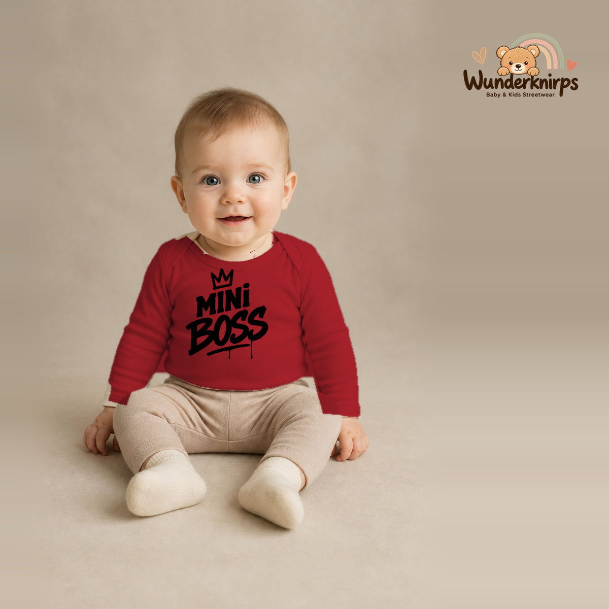 Babybody für Jungen in Rot mit Motiv „Mini Boss“, getragen von einem Kind – Wunderknirps.