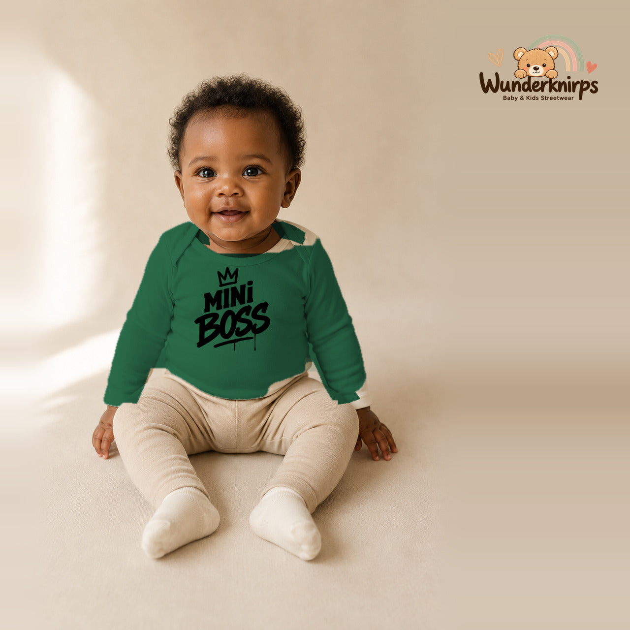 Babybody für Mädchen in Grün mit Motiv „Mini Boss“, getragen von einem Kind – Wunderknirps.