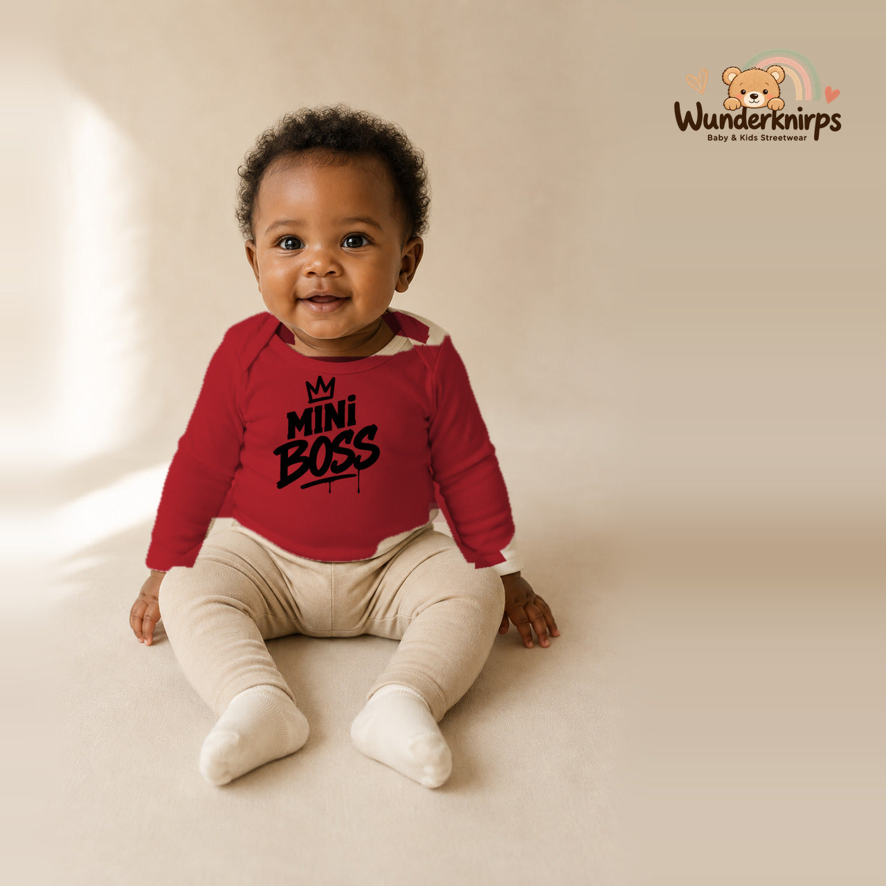 Babybody für Mädchen in Rot mit Motiv „Mini Boss“, getragen von einem Kind – Wunderknirps.