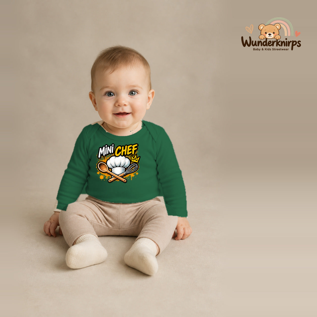 Babybody für Jungen in Grün mit Motiv „Mini Chef“, getragen von einem Kind – Wunderknirps.