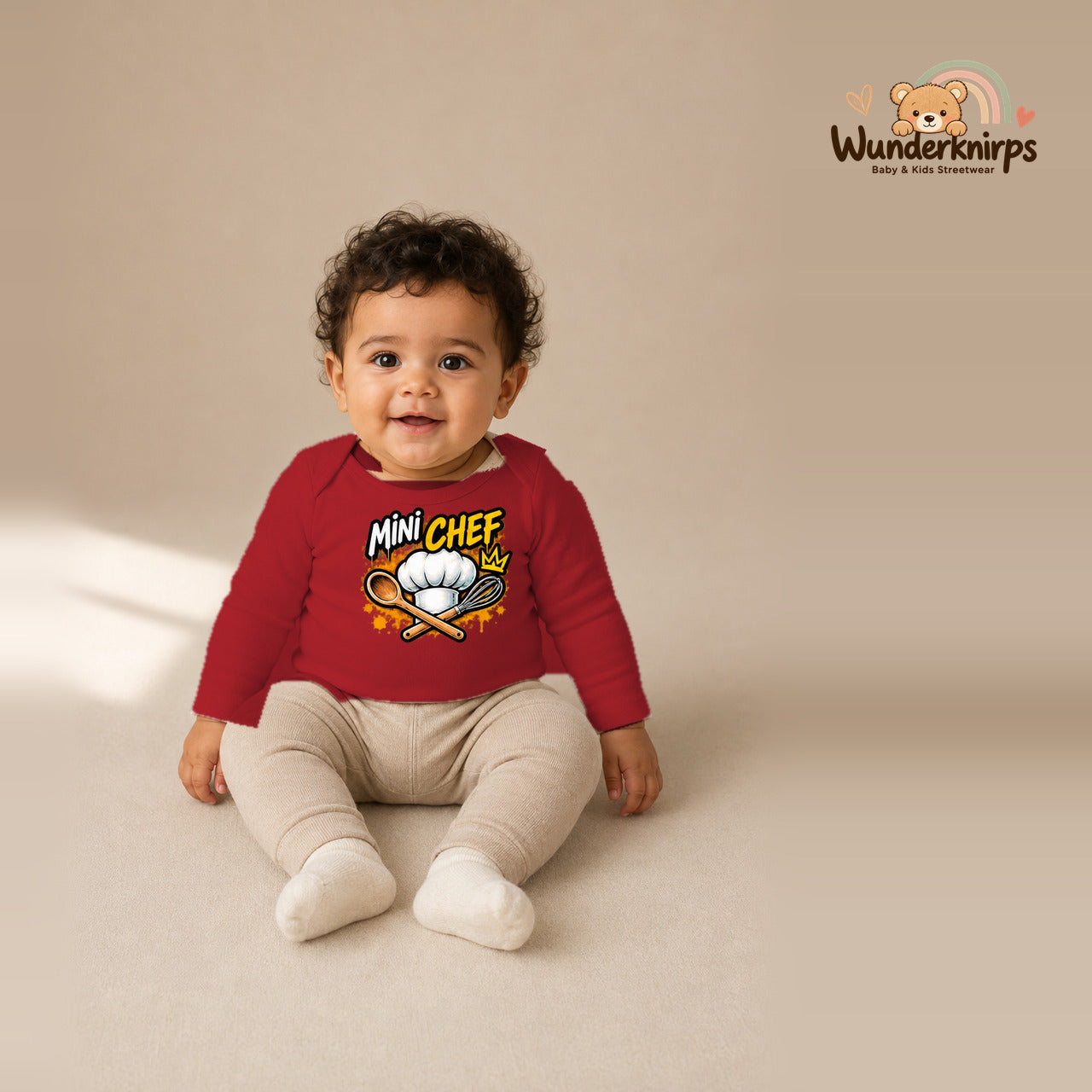 Babybody für Jungen in Rot mit Motiv „Mini Chef“, getragen von einem Kind – Wunderknirps.