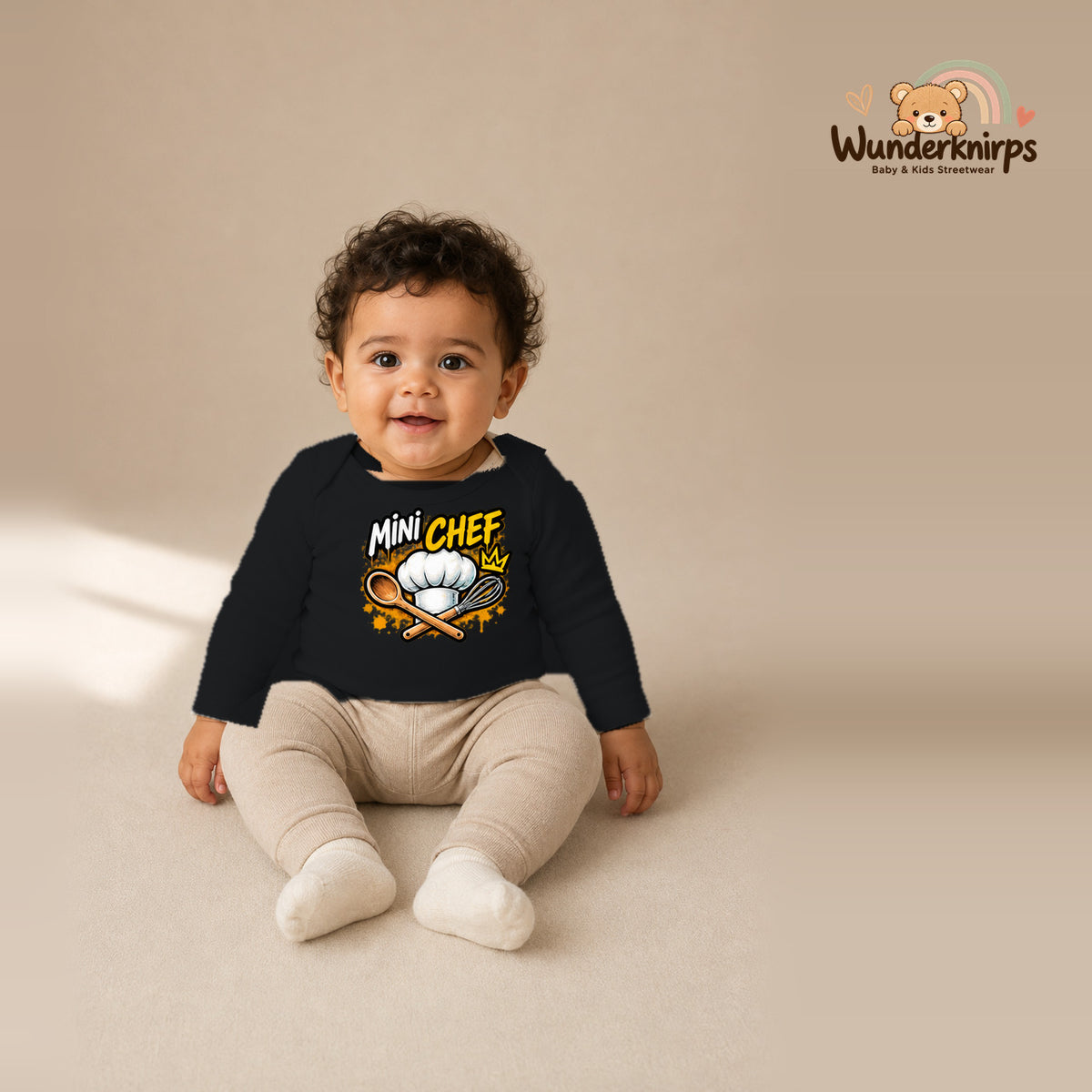 Babybody für Jungen in Schwarz mit Motiv „Mini Chef“, getragen von einem Kind – Wunderknirps.
