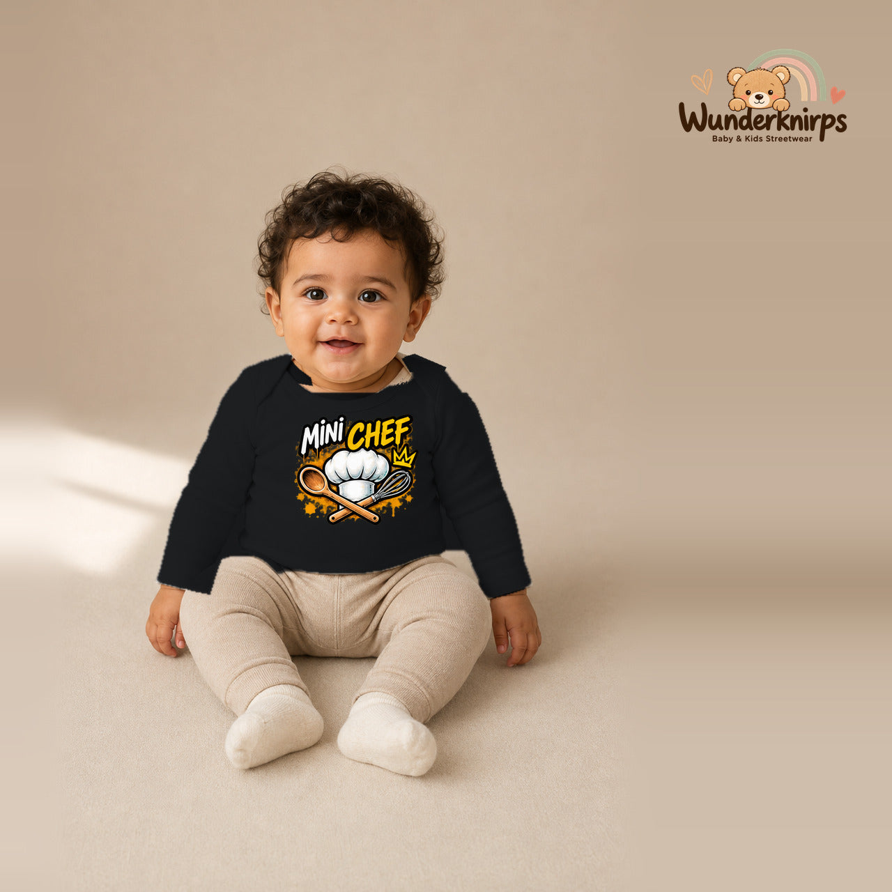 Babybody für Jungen in Schwarz mit Motiv „Mini Chef“, getragen von einem Kind – Wunderknirps.