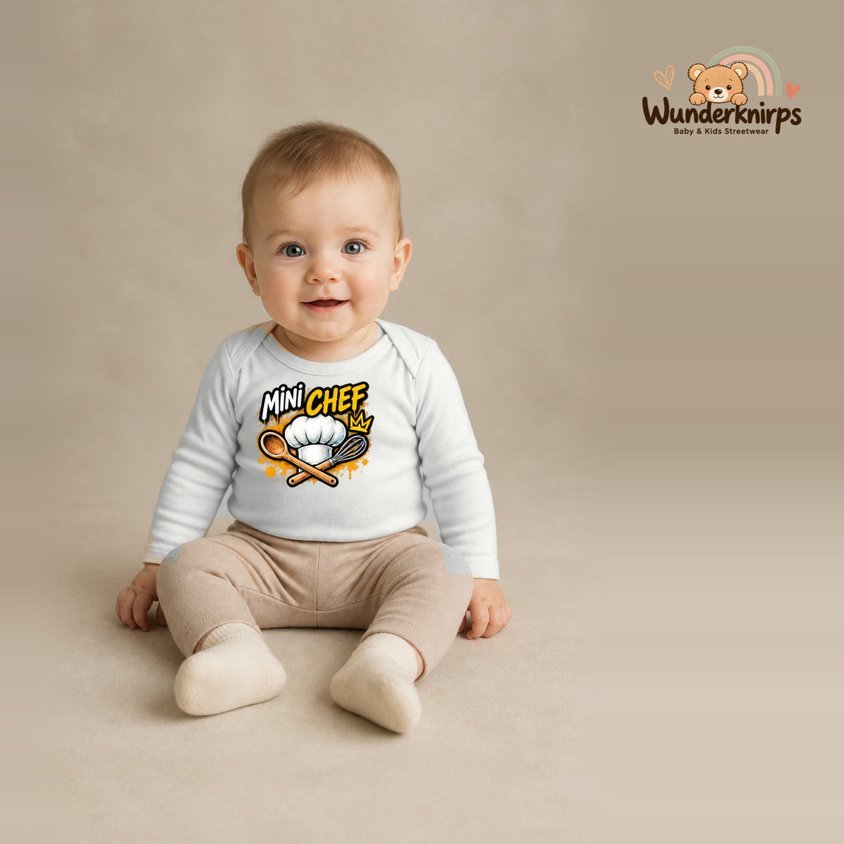Babybody für Jungen in Weiß mit Motiv „Mini Chef“, getragen von einem Kind – Wunderknirps.
