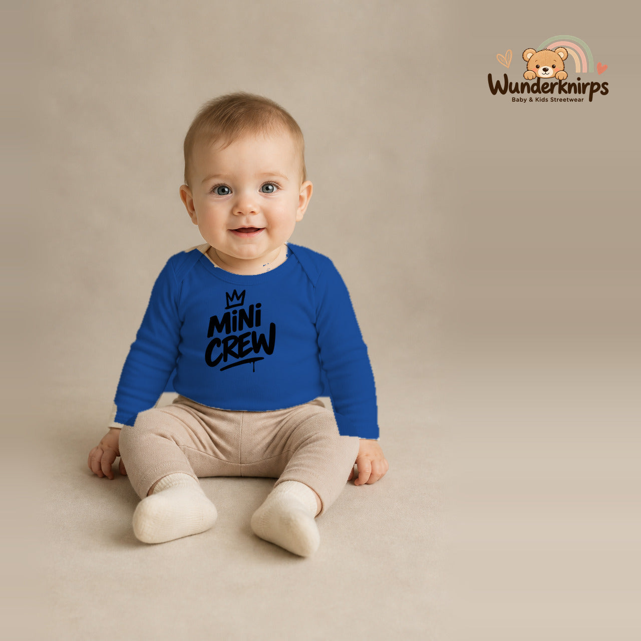 Babybody für Jungen in Blau mit Motiv „Mini Crew“, getragen von einem Kind – Wunderknirps.