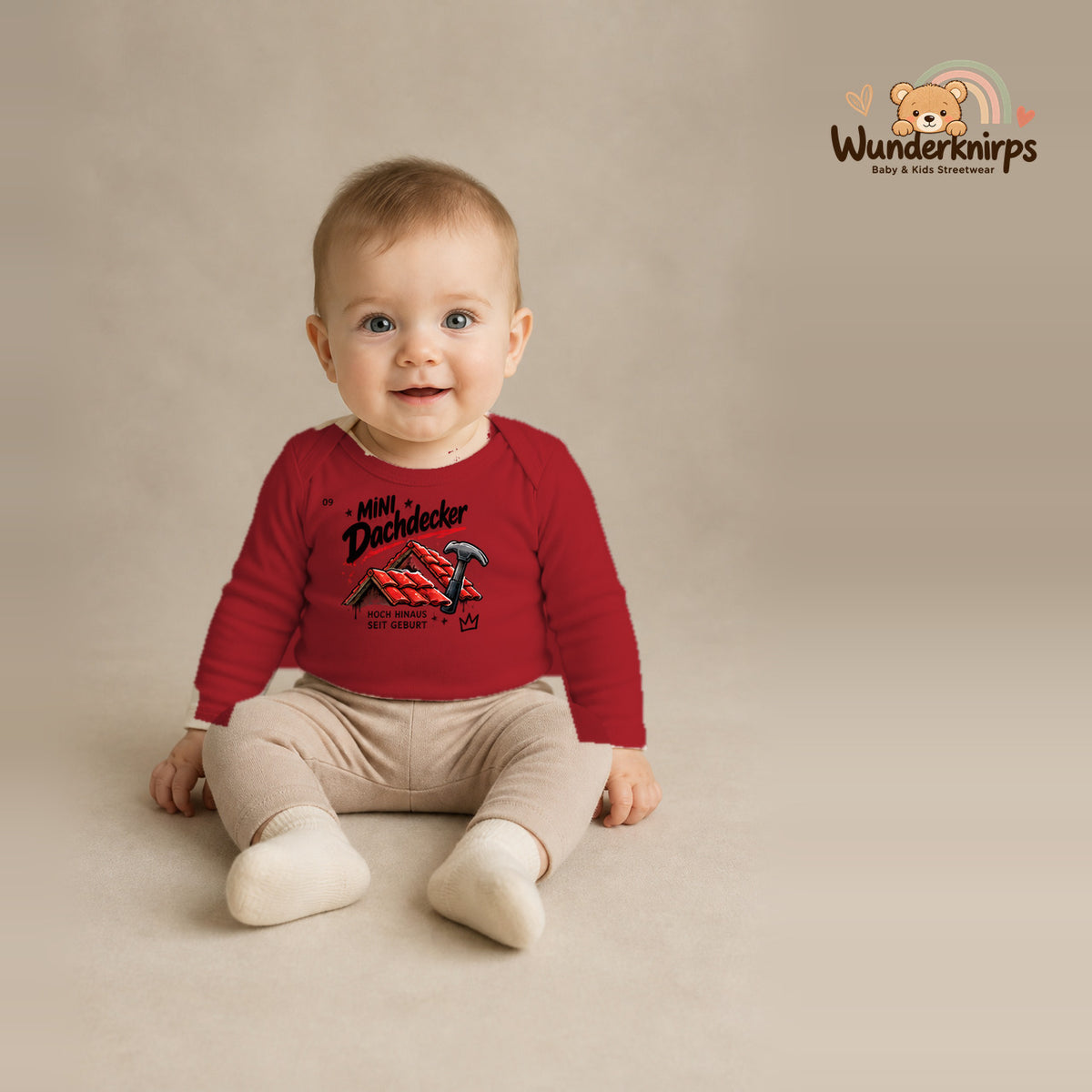 Babybody für Jungen in Rot mit Motiv „Mini Dachdecker“, getragen von einem Kind – Wunderknirps.