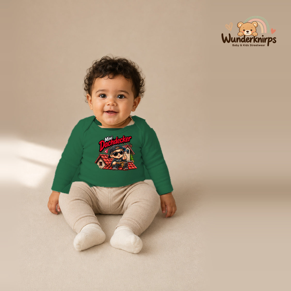 Babybody für Jungen in Grün mit Motiv „Mini Dachdecker“, getragen von einem Kind – Wunderknirps.