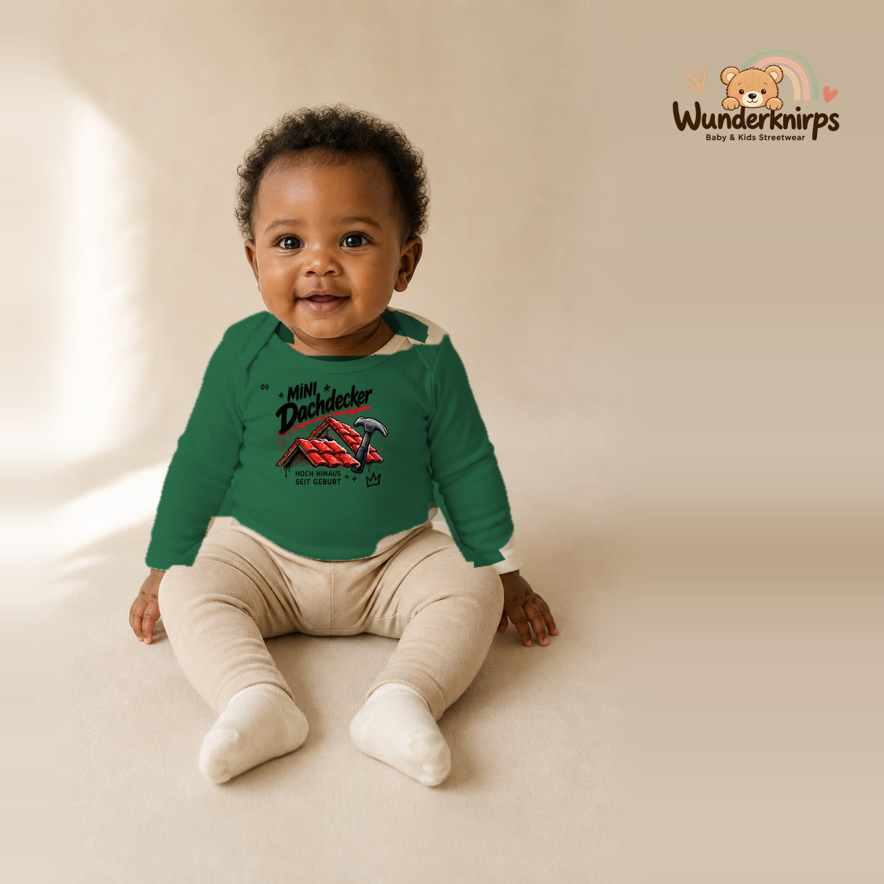 Babybody für Mädchen in Grün mit Motiv „Mini Dachdecker“, getragen von einem Kind – Wunderknirps.