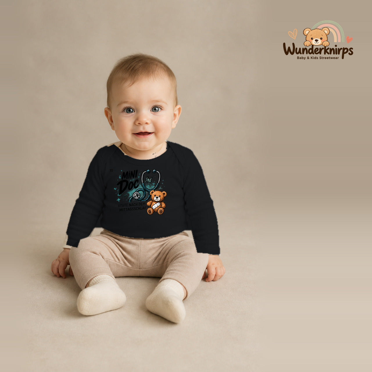 Babybody für Jungen in Schwarz mit Motiv „Mini Doc“, getragen von einem Kind – Wunderknirps.