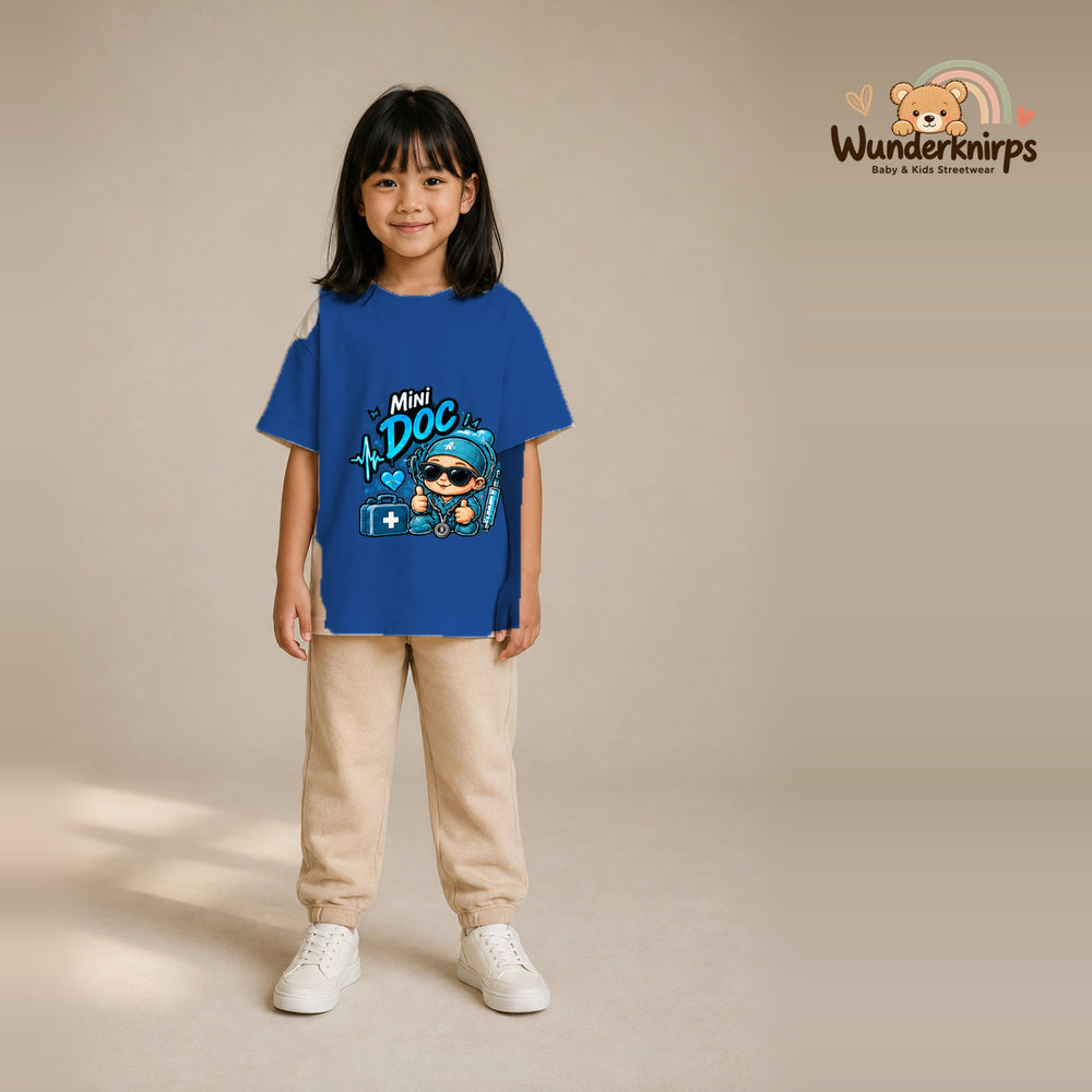T-Shirt für Mädchen in Blau mit Motiv „Mini Doc“, getragen von einem Kind – Wunderknirps.