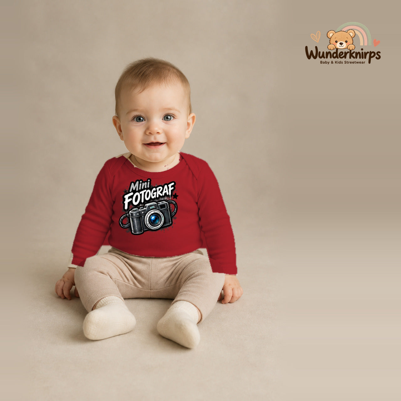 Babybody für Jungen in Rot mit Motiv „Mini Fotograf“, getragen von einem Kind – Wunderknirps.