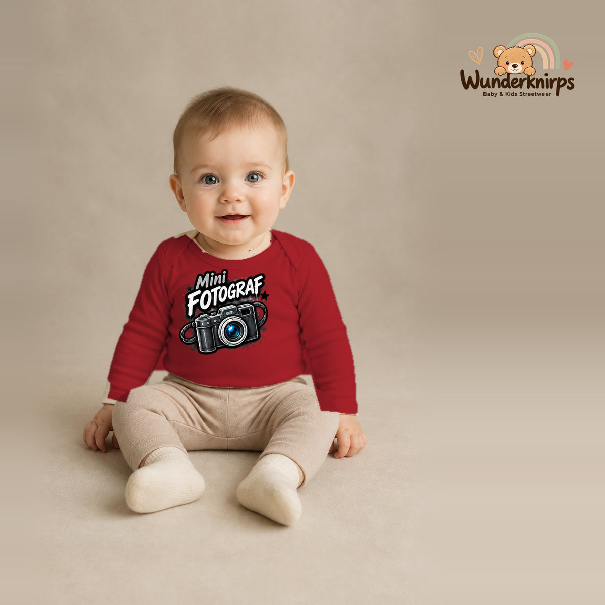 Babybody für Jungen in Rot mit Motiv „Mini Fotograf“, getragen von einem Kind – Wunderknirps.