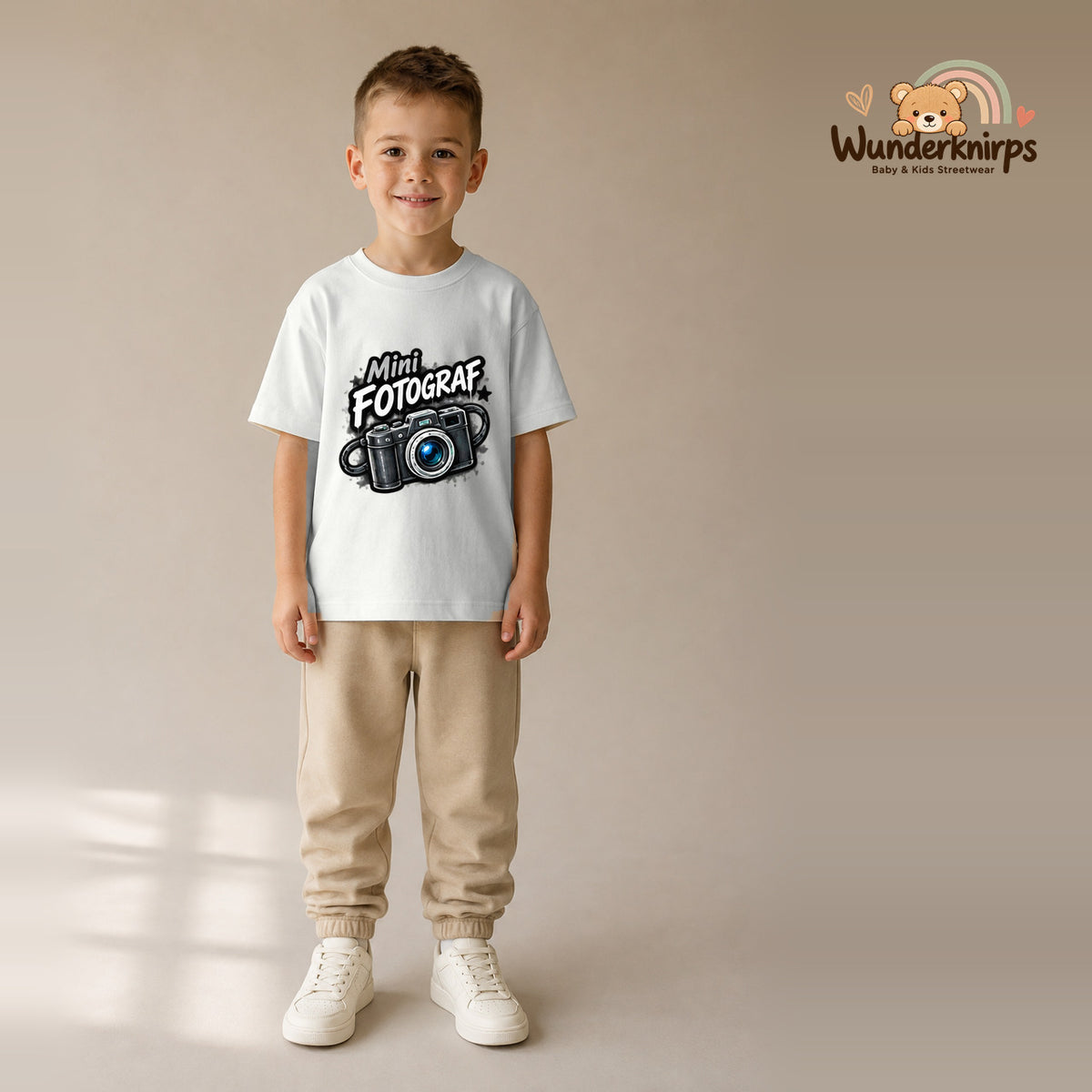 T-Shirt für Jungen in Weiß mit Motiv „Mini Fotograf“, getragen von einem Kind – Wunderknirps.