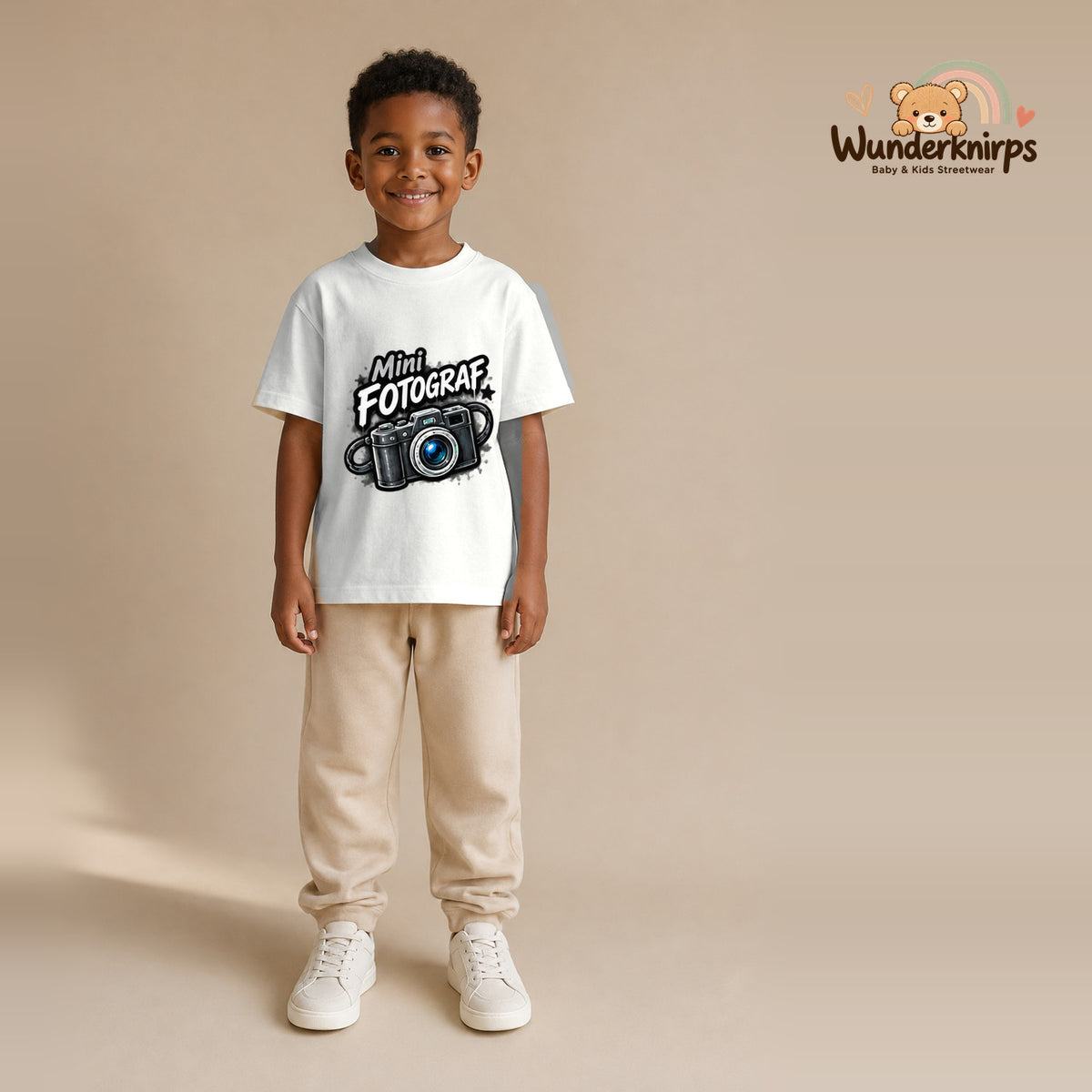 T-Shirt für Jungen in Weiß mit Motiv „Mini Fotograf“, getragen von einem Kind – Wunderknirps.