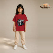 T-Shirt für Mädchen in Rot mit Motiv „Mini Fotograf“, getragen von einem Kind – Wunderknirps.