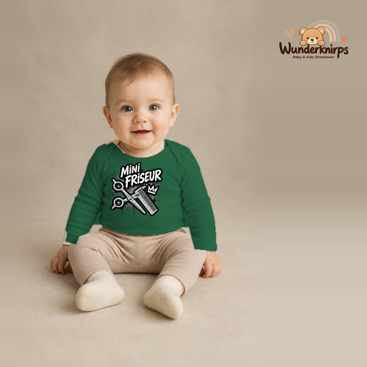 Babybody für Jungen in Grün mit Motiv „Mini Friseur“, getragen von einem Kind – Wunderknirps.